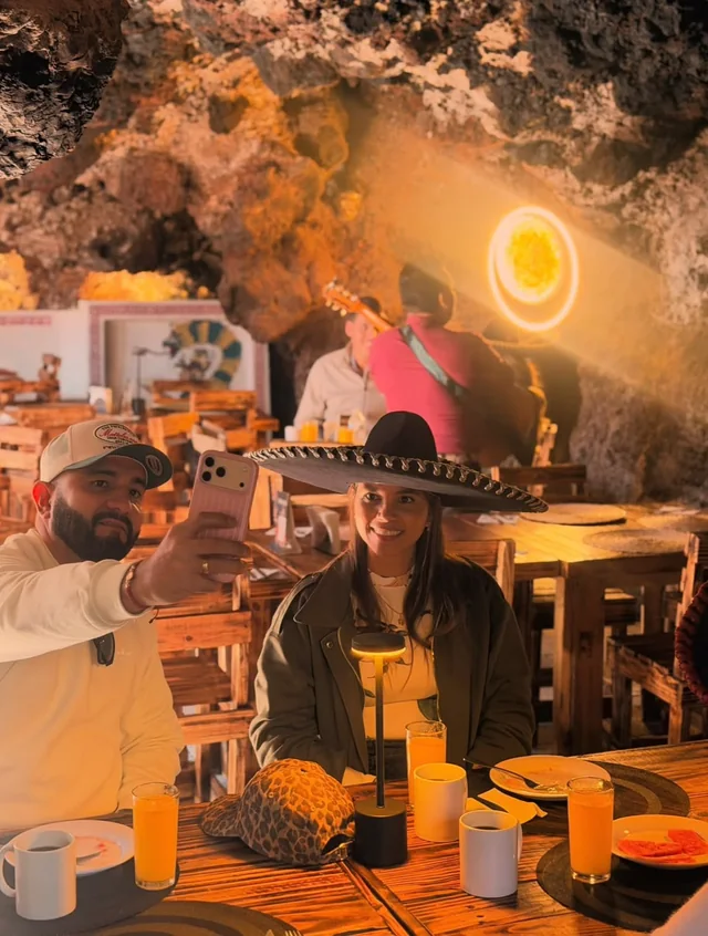 Pareja tomándose una selfie con sombrero de charro durante el desayuno