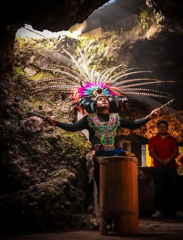 Danzante con penacho de plumas a la entrada de la cueva