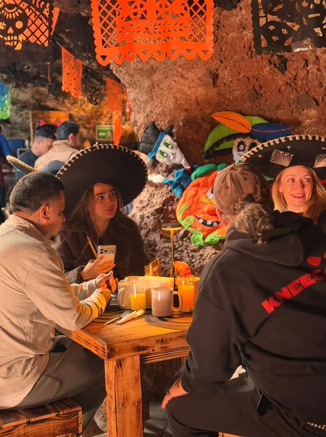 Amigos con sombreros de charro desayunando en la cueva