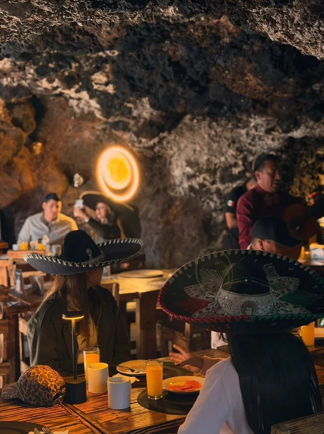 Pareja con sombreros mexicanos a la luz de una lámpara en forma de sol