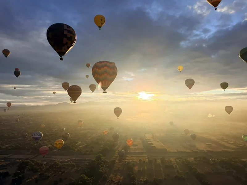 Decenas de globos aerostáticos elevándose al salir el sol