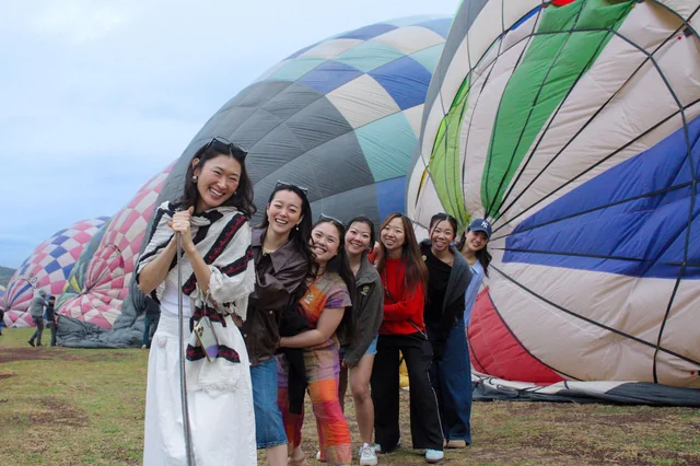 Grupo de amigas ayudando a sostener el globo durante el inflado